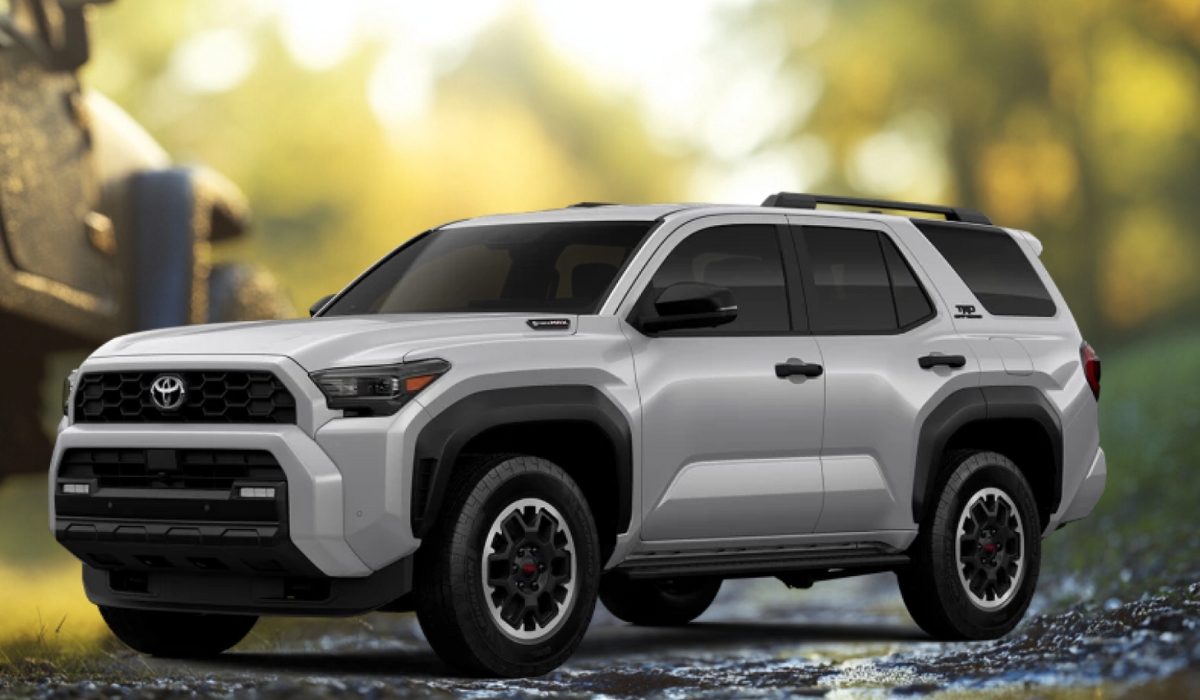 Silver Toyota 4Runner Trailhunter SUV parked on a forest trail with black wheels and Trailhunter badging, set against a blurred nature background